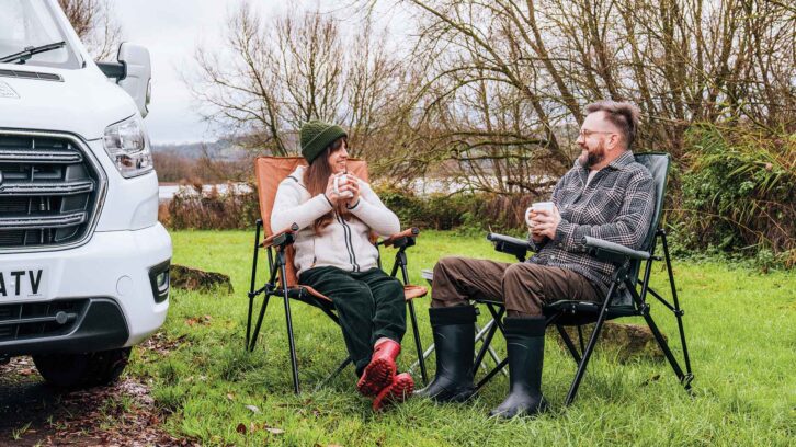 Two people talking by a motorhome