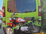 A motorbike attached to the back of a motorhome