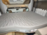 A double mattress on a drop-down bed in a motorhome.