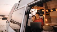 A couple in a campervan on a laptop