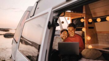 A couple in a campervan on a laptop