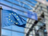 uropean Union flags in front of the blurred European Parliament in Brussels, Belgium
