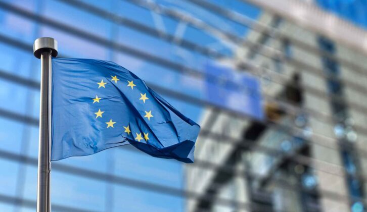 uropean Union flags in front of the blurred European Parliament in Brussels, Belgium