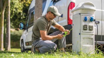 A man setting up electric hook-up for his campervan