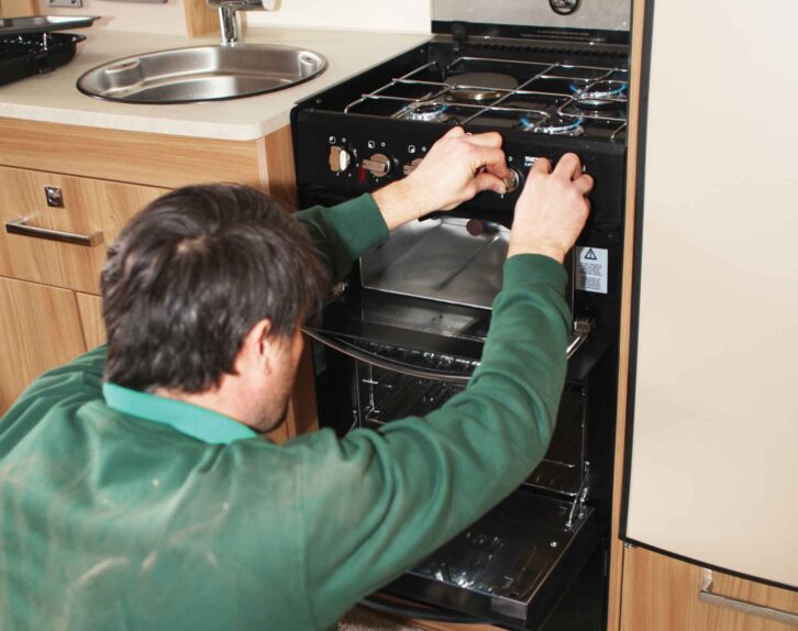 A technician checking the burn and the cut-off of the cooker