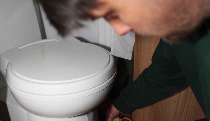 A technician using a damp meter around hte toilet