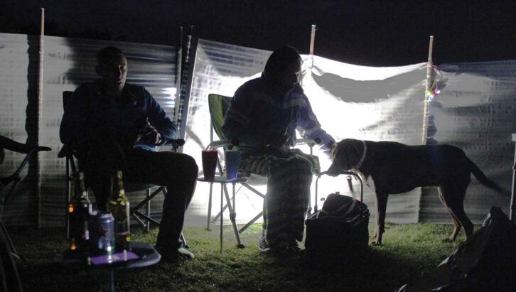 People outdoors in the evening at a campsite
