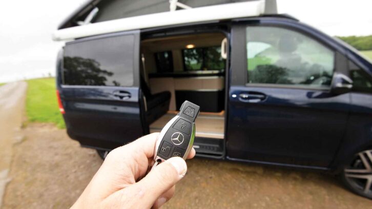 Holding a key fob by a campervan