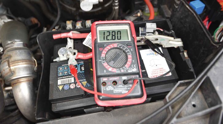 A multimeter displaying a reading of 12.80V