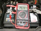 A multimeter showing a reading of 14.11V