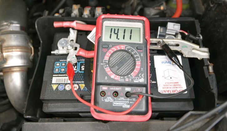 A multimeter showing a reading of 14.11V