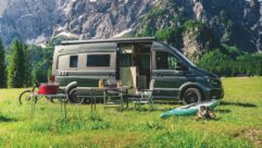 MegaMobil campervan parked in a field and surrounded by outdoor-activity products