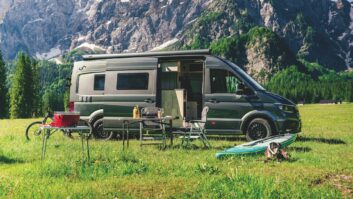 MegaMobil campervan parked in a field and surrounded by outdoor-activity products