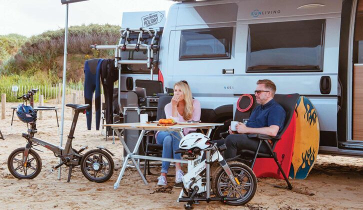 A man and woman sitting under a canopy with folded bikes nearby