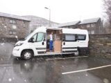 A campervan in a parking bay on a wet day