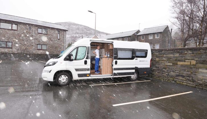A campervan in a parking bay on a wet day