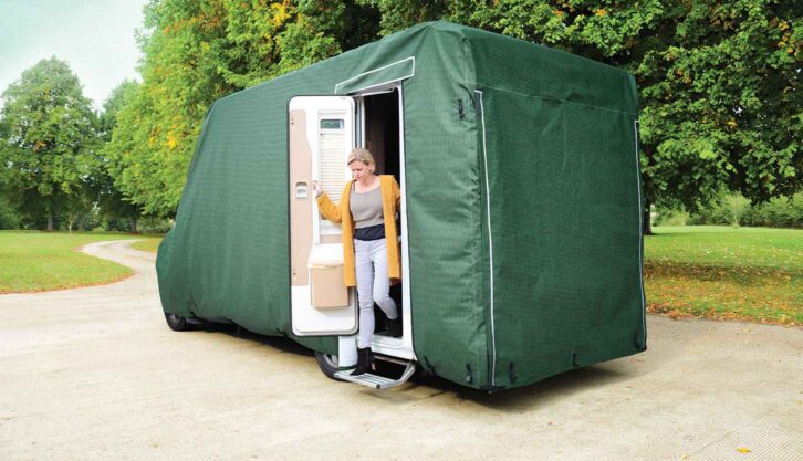 A person getting out of a motorhome which has a cover on