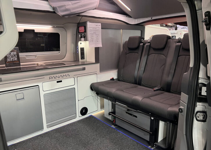 The interior of the P10E, with all-electric kitchenette and three travel seat-bench.