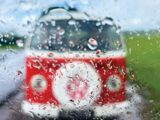 Loking out of a rainy window to see a blurry red campervan