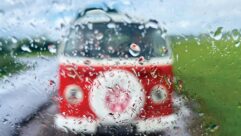 Loking out of a rainy window to see a blurry red campervan