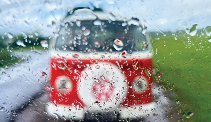 Loking out of a rainy window to see a blurry red campervan