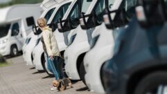 A person standing inwith their back to a row of motorhomes