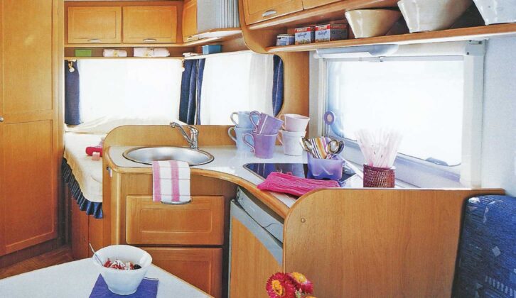 The permanent low-level European-style rear-corner bed can be seen behind the kitchen