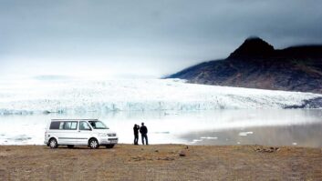 A couple standing by their campervan enjoying the view in Iceland