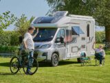 Peter with a bike waving to someone relaxing outside their motorhome