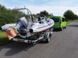 A RIB being towed by a campervan on a trailer