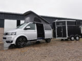 A campervan towing a horsebox
