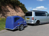 A campervan with a small camping pod on the back