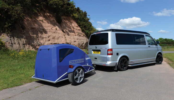 A campervan with a small camping pod on the back