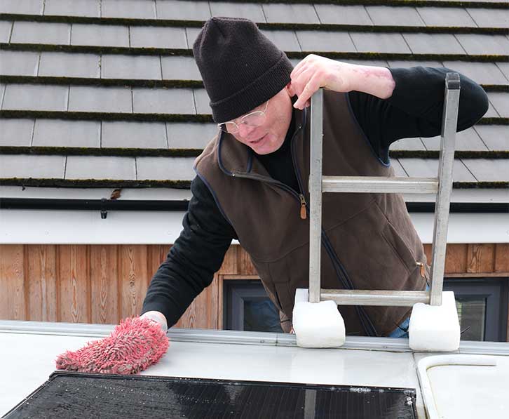 A man cleaning the roof of a motorhome