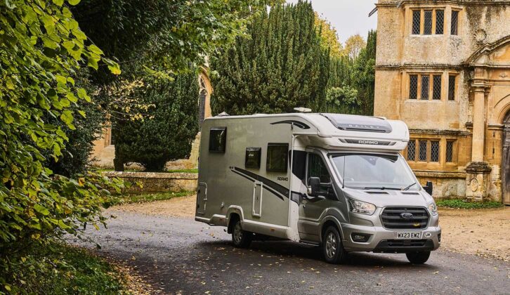 A motorhome parked up by trees