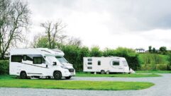 A motorhome and caravan on pitches at a campsite