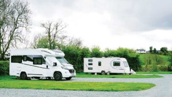 A motorhome and caravan on pitches at a campsite