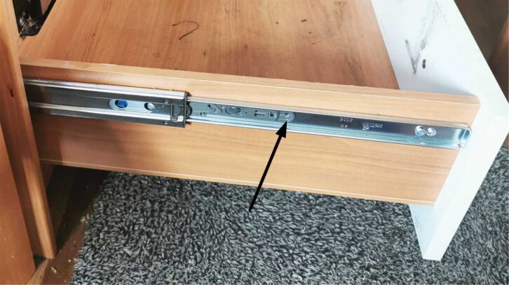 An arrow pointing at where to slide it to to release the drawer from slides
