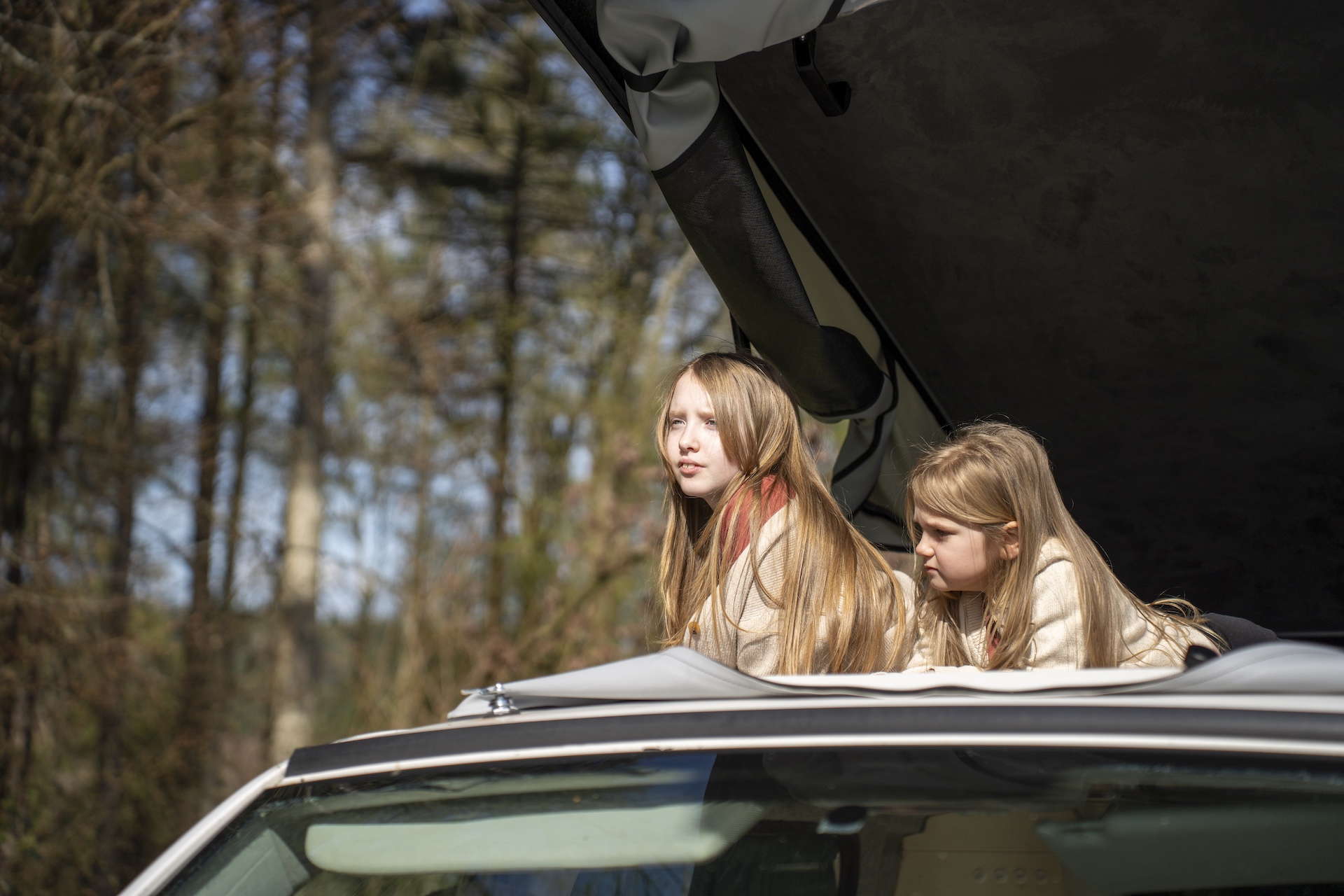 Two children in the pop-top roof of a campervan