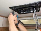 Screwing the air-con unit into place
