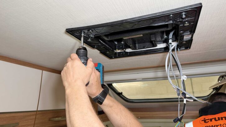 Screwing the air-con unit into place
