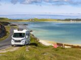 A motorhome parked in the Outer Hebrides with Barra Airport in the background