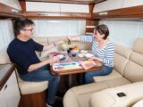 Two people eating a meal inside a Carthago motorhome