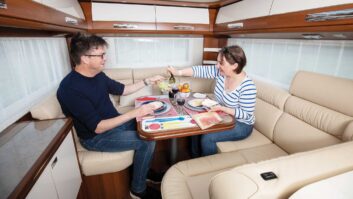Two people eating a meal inside a Carthago motorhome