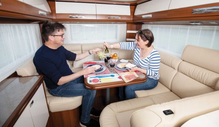 Two people eating a meal inside a Carthago motorhome