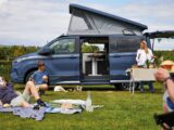 A Swift Monza with its roof up while a family relax on their pitch