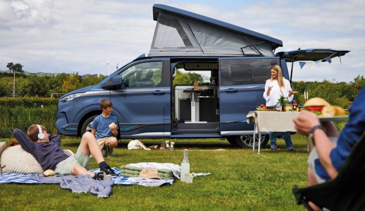 A Swift Monza with its roof up while a family relax on their pitch
