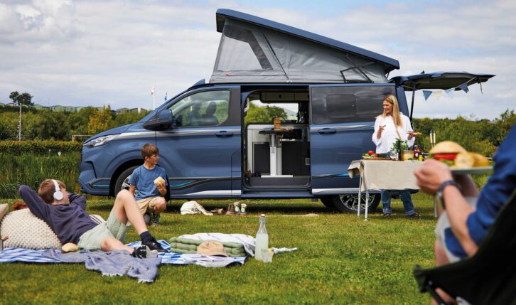 A Swift Monza with its roof up while a family relax on their pitch
